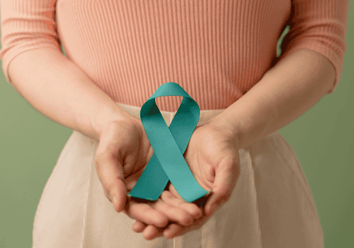 Teal awareness ribbon held in hands
